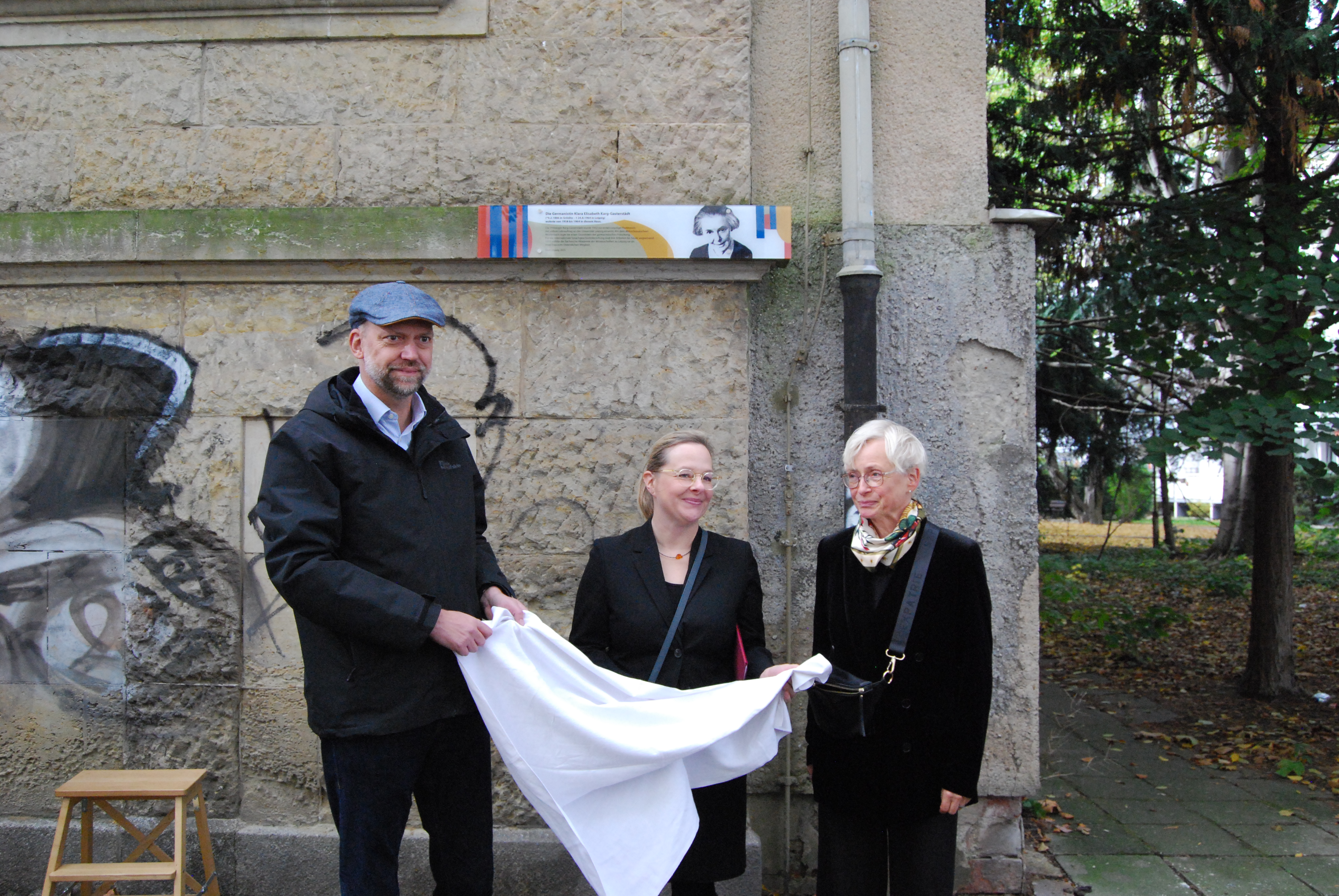 Plakette nach der Enthüllung. Personen von links nach rechts: Tobias Kobe, amtierender Leiter des Kulturamtes, Dr. Kerstin Hohner von der Sächsischen Akademie der Wissenschaften, die Leipziger Künstlerin Christiane Werner. Foto: Sächsische Akademie der Wissenschaften / Birgit Pfeiffer