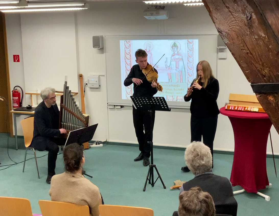 Musikalische Präsentation des Sequenzschemas 'Aurea' aus 'Liber Hymnorum Notkeri Balbuli', gespielt in pythagoreischer Stimmung von Veit Heller (Portativ, links), Jonas Heller (Fiedel, Mitte) und Lucretia Winter (Flöte, rechts). Foto: Jonas Heller