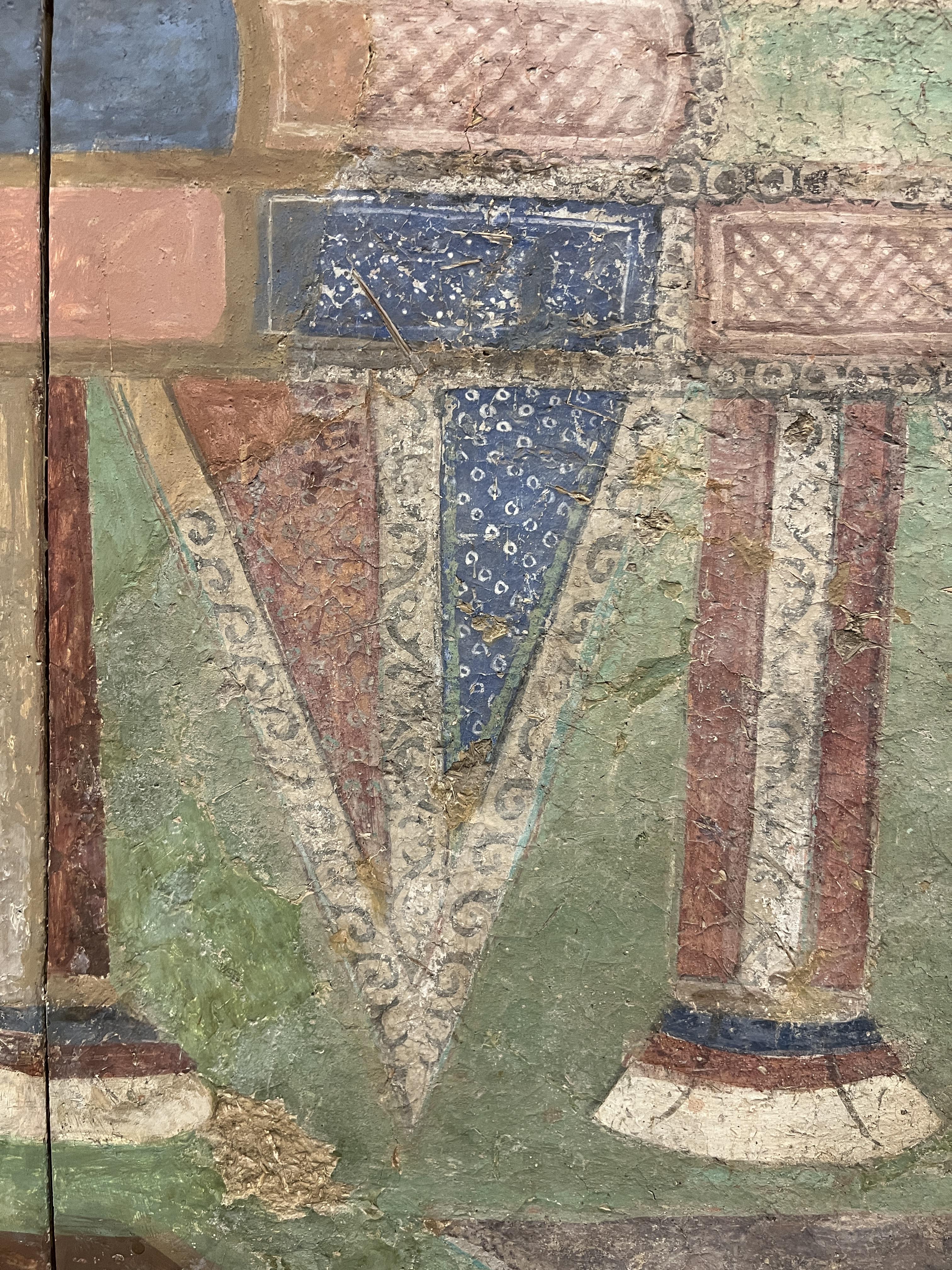 Wallpainting fragment depicting geometrical shapes of rectangles and combined triangles in different cloures such as blue, beige on a light green background.
