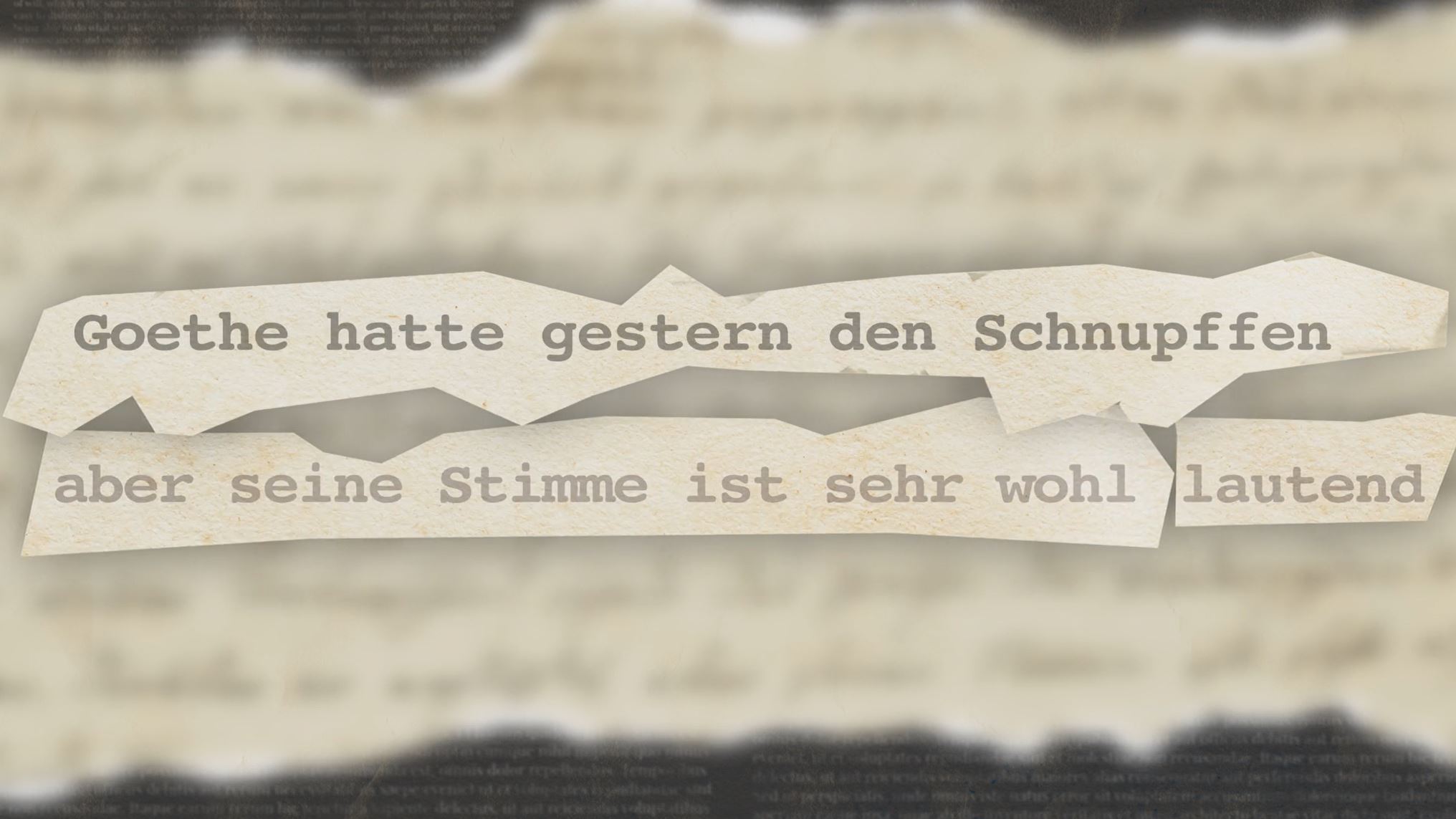 Schriftzug in klassischer XML-Typographie vor unscharfem Hintergrund: "Goethe hatte gestern den Schnupffen aber seine Stimme ist sehr wohl lautend.