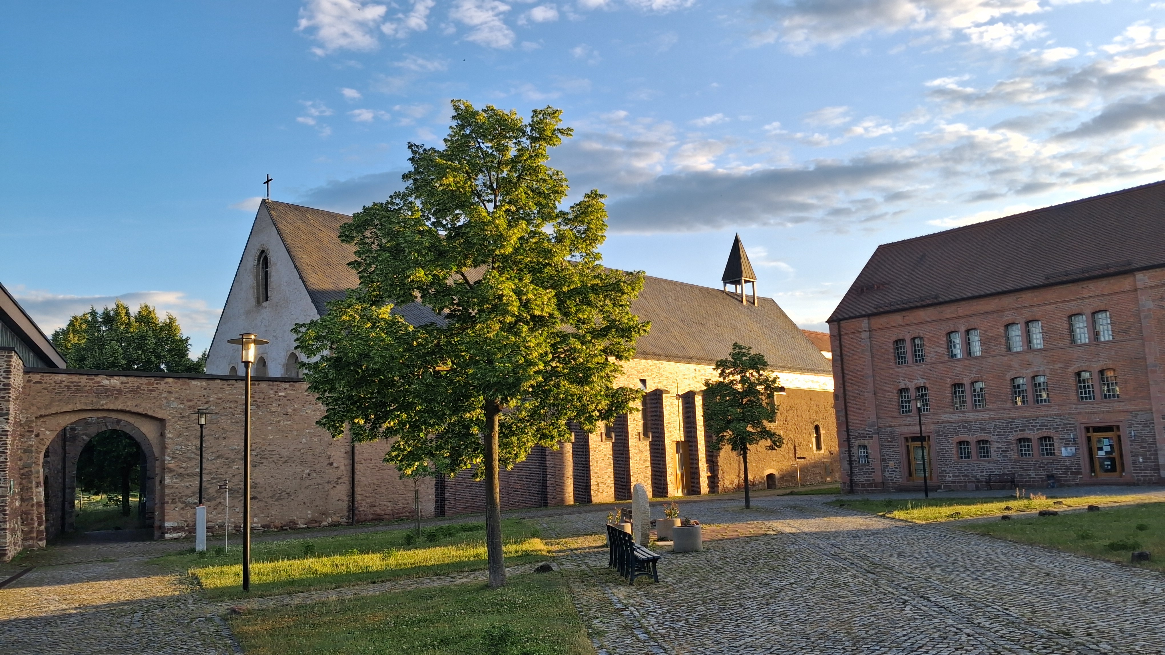 Die Kirche in Helfta mit einer Rasenfläche davor und einem Tor neben der Kirche auf der linken Seite des Bildes
