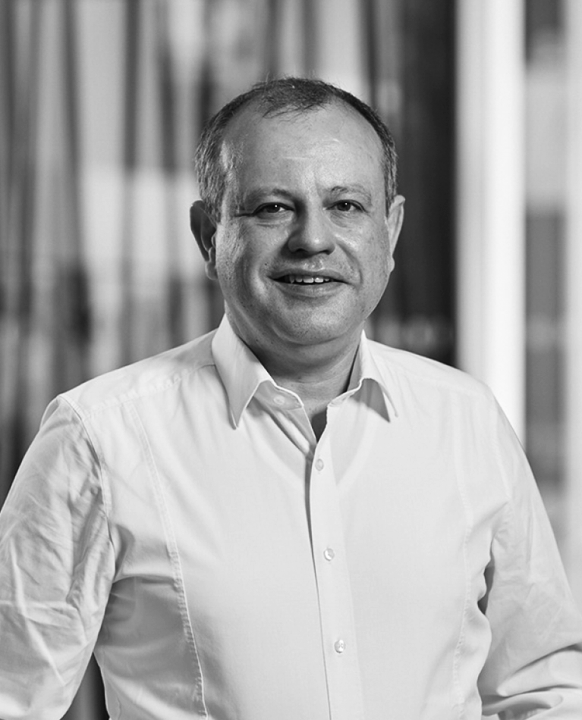 A black-and-white portrait photograph of a smiling man